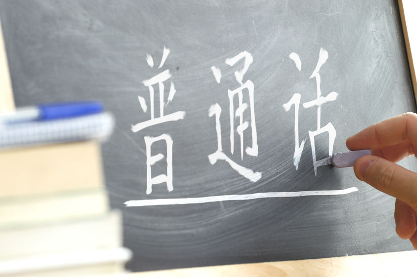 Escriptura a mà en una pissarra en una classe de xinès. Alguns llibres i materials escolars.